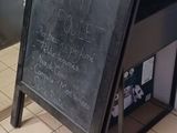 a blackboard sign on the floor in front of a building