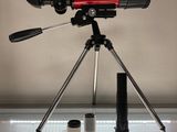 une image représentant un télescope posé sur un trépied à côté d'un appareil photo