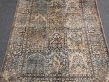 un tapis persan ancien aux motifs bleus et beiges