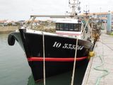 un bateau noir et rouge amarré à un quai