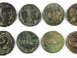 a group of six ancient roman coins on a white surface