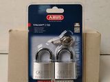 a close up of two padlocks in a package on a table