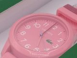 a pink watch in a green box with a pink strap