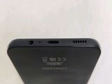 the back of a black cell phone sitting on top of a white table