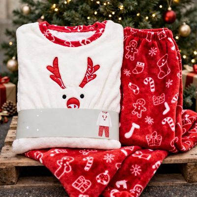 un gros plan sur un pyjama de Noël et un ordinateur portable posés sur une caisse en bois