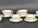 un grand nombre de tasses et de soucoupes sur une table