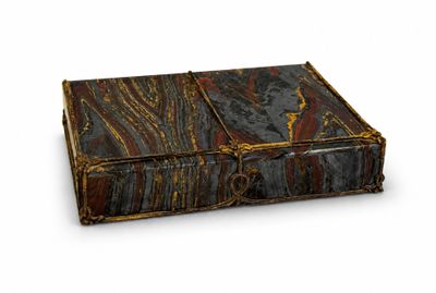 an old book with a leather cover on a white surface