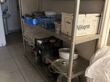 many plates and pans on a metal shelf in the kitchen