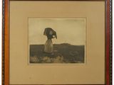 une vieille photo représentant une femme avec un parapluie, debout dans un champ