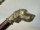 a silver dog head on a cane with a wooden handle