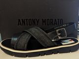 a close up of a pair of black sandals with a box in the background