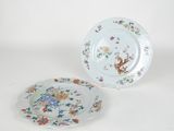 two plates with floral designs on them sitting next to each other