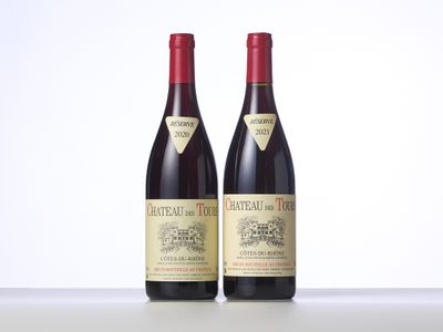 two bottles of red wine sitting on top of a table