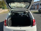 a white car with its trunk open in a parking lot