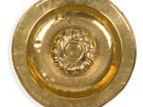 une assiette en or ornée d'un motif sur fond blanc