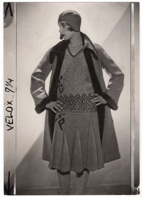 photographie en noir et blanc d'une femme vêtue d'une robe et d'un manteau