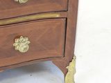 a small chest of drawers with a clock on top of it