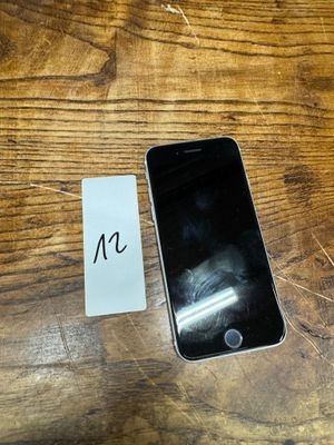 a cell phone sitting next to a note on a wooden table