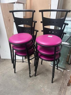 pair of black and pink metal chairs with pink cushions