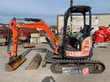 une petite excavatrice garée sur un terrain