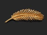 un gros plan d'une broche en feuille d'or sur fond noir