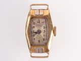 a gold watch that is sitting on a white surface