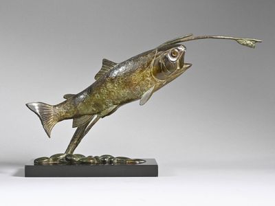 bronze sculpture of a fish on a black base on a gray background