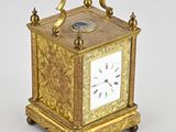 une horloge en or surmontée d'un oiseau