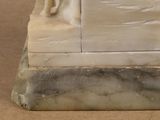 a statue of a woman sitting on top of a marble base