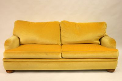 une image représentant un canapé jaune posé sur un sol blanc