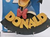 a statue of donald the duck in front of a box
