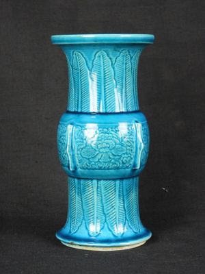 un vase bleu posé sur une surface noire