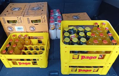 two yellow crates filled with bottles of soda sitting in the back of a car