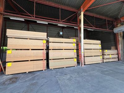 de nombreuses piles de bois dans un entrepôt au toit métallique