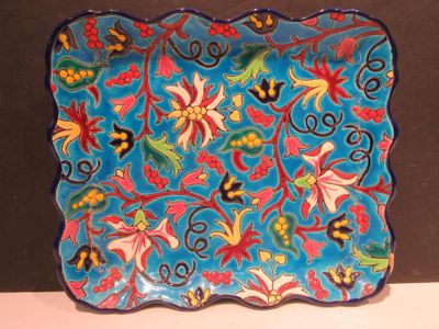 une assiette bleue ornée de fleurs colorées, posée sur une table