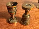 deux bougies en métal posées sur une table en bois