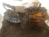 a small table with an old fashioned iron and a wooden box on it