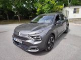 La voiture grise est garée dans la rue, devant une maison.