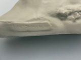 a sculpture of a woman ' s face on a white surface