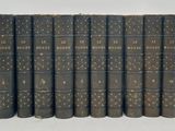 six vieux livres alignés sur une surface blanche
