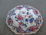 une assiette décorée de fleurs et d'oiseaux, posée sur une table