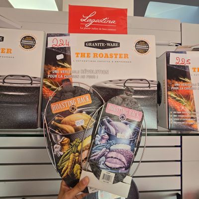 une personne tenant un plat à rôtir devant un étalage de produits alimentaires