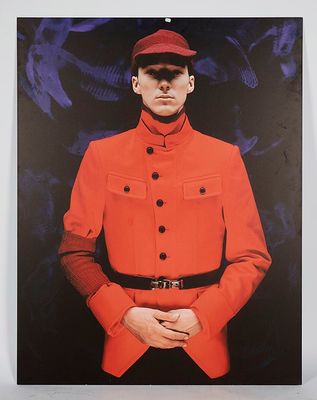 une photo d'un homme en uniforme rouge posant pour une photo
