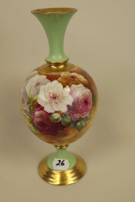 a vase with flowers painted on it sitting on a table