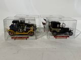 two toy cars in a clear box on a white surface