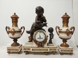 trois vases et une horloge posés sur une table