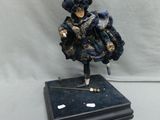 figurine représentant une femme en robe bleue tenant une canne