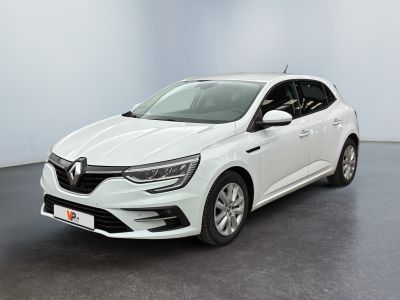Une voiture blanche est garée dans une pièce au sol noir.