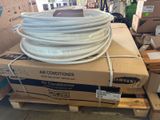 une pile de cartons sur laquelle sont posés plusieurs tuyaux blancs