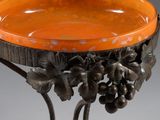 an orange bowl with a bunch of grapes on it